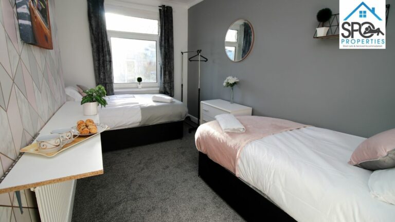 Twin bedroom with two single beds and clothes storage – contractor stay in Pontypool, South Wales.
